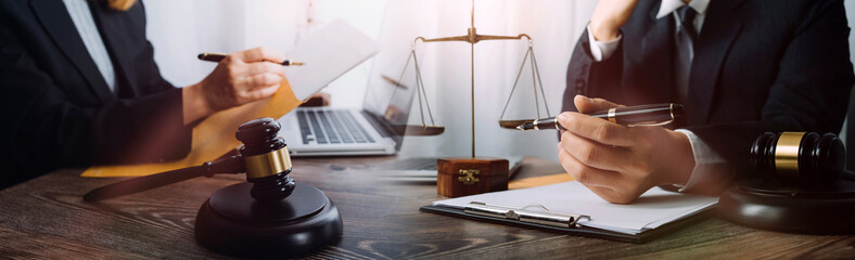 Justice and law concept.Male judge in a courtroom with the gavel, working with, computer and...
