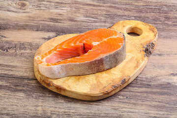 Raw salmon steak over board