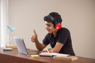 A HAPPY TEENAGER ATTENDING ONLINE CLASS