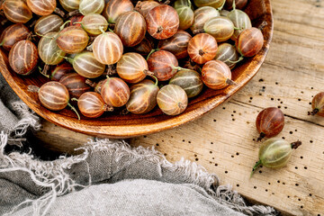 Red gooseberries on a wooden table.