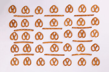 Pretzel cracker sticks laid in rows design angle straight on what background