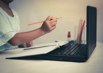 Young kid girl studying at home using a computer notebook laptop at home , education concept.