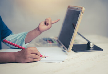 Young kid girl studying at home using a tablet , education concept.