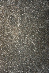 Rough grainy stone pebble pavement abstract vertical monochromatic gray background texture