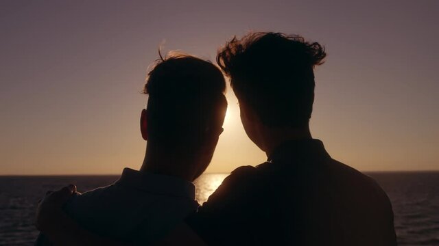 Gay couple hugging at sunset, boyfriend hugging partner, love relationship