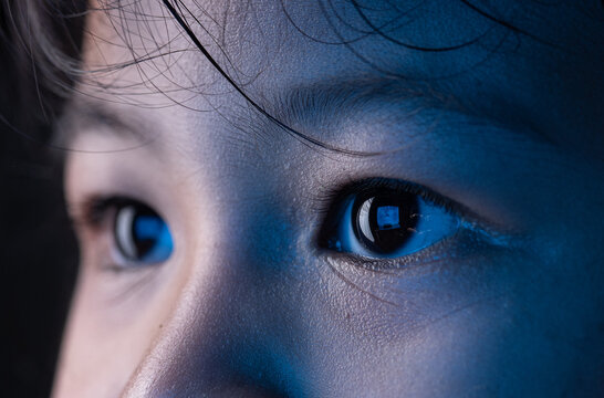 Little girl eyes looking at monitor, Monitor blue light is reflected in her eyes,effects on the eyes.