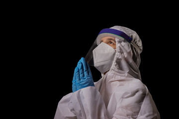 A doctor in PPE kit joining hands in prayer.