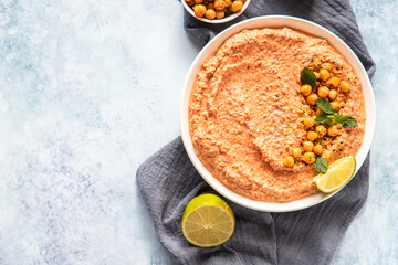 Roasted red pepper hummus garnish with mint and lime. Mashed chickpeas with red bell pepper, lime and mint. Vegetarian snack. Top view.