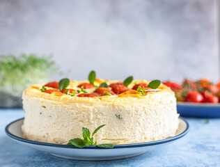 Savoury cheesecake with tomatoes decorated with mint, blue concrete background.