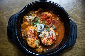 Spicy braised mackerel with kimchi and radish in a Ttukbaegi bowl, traditional Korean food