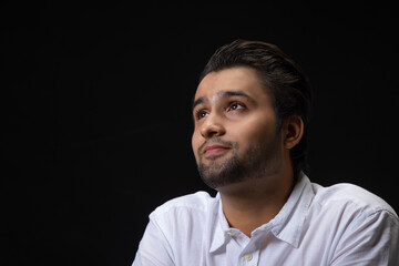 Portrait of a  young man smiling while thinking something.