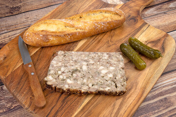 tranches de pâté de campagne et baguette de pain sur une planche à découper