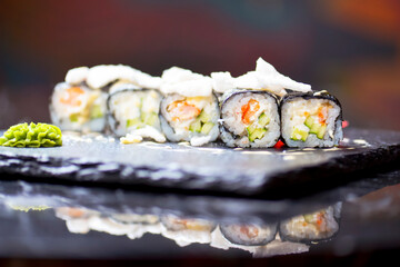 Japanese cuisine - sushi roll with avocado, cream cheese and shrimps inside. Topped with rice chips.