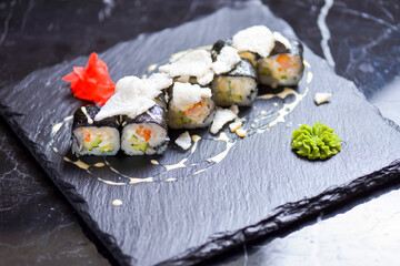 Japanese cuisine - sushi roll with avocado, cream cheese and shrimps inside. Topped with rice chips.