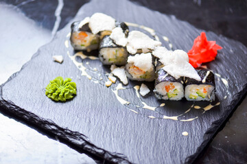 Japanese cuisine - sushi roll with avocado, cream cheese and shrimps inside. Topped with rice chips.