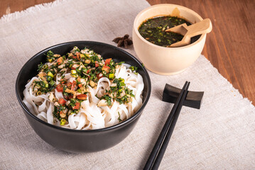Chinese vegan rice noodles in a cup with a spicy herb sauce.