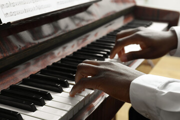 Obraz premium African-American man playing piano, closeup. Talented musician