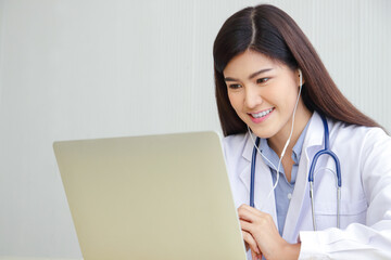 Asian female doctor online video call Check the symptoms with the patient via the Internet. on a laptop computer. The concept is connected to communication through online technology.