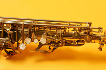 Beautiful saxophone on yellow background, closeup view