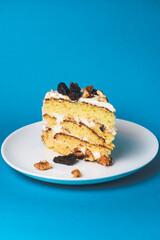 Pistachio cake, sponge cake with nuts decoration on a white plate. One piece of freshly baked cake.