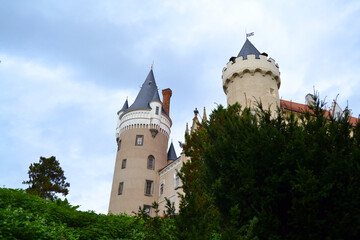 Fototapeta premium Medieval Žleby castle (Zámek Žleby) on autumn day. Žleby, The Central Bohemian Region, Czech Republic. Tree branches in the foreground