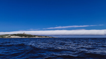 Fototapeta na wymiar Large cigar cloud rolling in off the coast at Narooma, New South Wales, Australia
