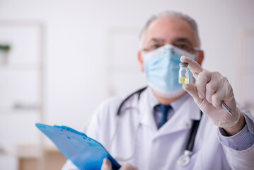 Fototapeta premium Old male doctor working in the clinic