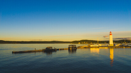 Sunset over the Cabano lighthouse and Temiscouata's marina, with the paper mills smoke in the background