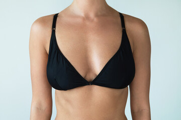 Fototapeta na wymiar Woman with natural breast wearing black swimwear top