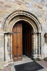 Medieval stone arch with heavy wooden door half open in Europe