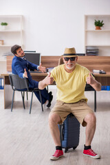 Old boss and young male employee in summer vacation concept