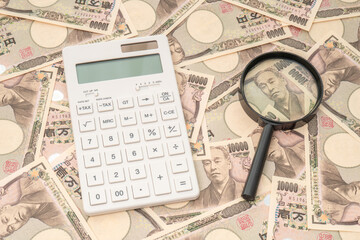 Many Japanese 10000 yen bills, calculators and magnifying glass