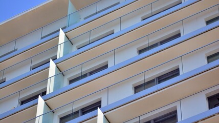 New apartment building with glass balconies. Modern architecture houses by the sea. Large glazing on the facade of the building.