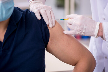Young male patient visiting old male doctor in vaccination conce