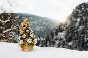 Beautiful winter landscape with a Christmas tree decorated in yellow colors. Christmas tree symbol.