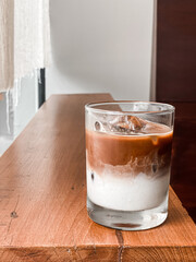 a glass of coffee on wood table in cafe minimal style