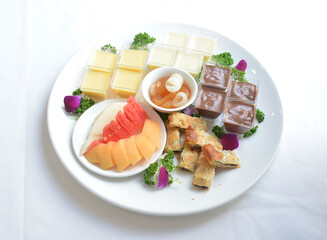 cold sweet dessert platter with pudding, mango, fruits, deep fried red bean paste, jelly, strawberry, watermelon, almond, longan, lychee in white background asian halal menu