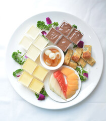 cold sweet dessert platter with pudding, mango, fruits, deep fried red bean paste, jelly, strawberry, watermelon, almond, longan, lychee in white background asian halal menu