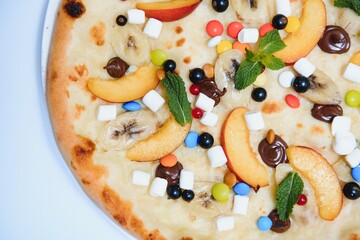 Sweet pizza with marshmallow sauce and colored sweets, chocolate pizza with colored sweets and chocolate pizza with banana on a white background