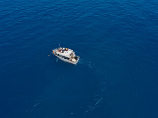 Aerial view of a fishing vessel in the blue sea off the coast of Calabria, Italy