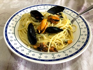 Eating spaghetti pasta with mussels