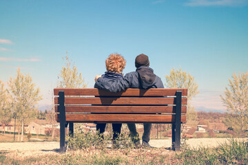 Old lovers on a bench. Couple enjoying together the nature (they resting in a park)