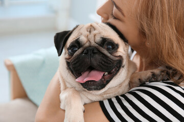 Woman with cute pug dog at home. Animal adoption