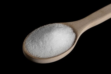 Sugar pile in wooden spoon isolated on black background, clipping path