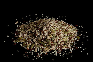 Mixed seeds pile with sunflower, sesame, linseed, pumpkin seed isolated on black background