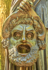 Antique sculpture depicting the tragic mask of the ancient theater