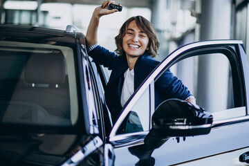 Beautiful business woman in a car showroom