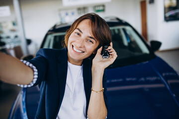 Beautiful business woman in a car showroom