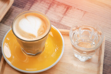 Latte hot coffee (or cappuccino) on wooden table background.