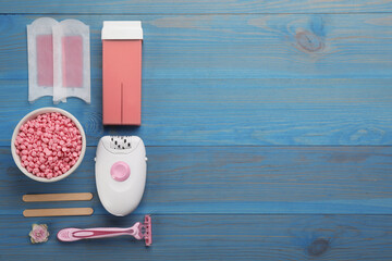 Set of epilation products on light blue wooden table, flat lay. Space for text